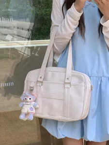 Vista di dettaglio della borsa tote JK giapponese in pelle beige con grazioso ciondolo in peluche.
