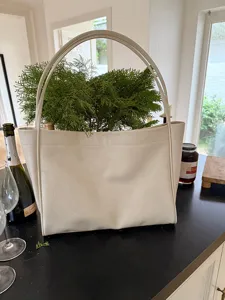Detailed scene showcasing off-white soft leather casual tote bag on black counter.