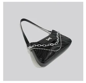 Black baguette underarm bag detail showcasing the wavy texture, silver chains, and butterfly charm.