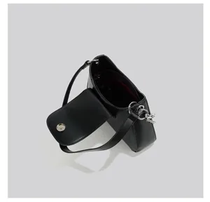 Detailed close-up view of the chic black underarm bag showing texture and metallic chain hardware.