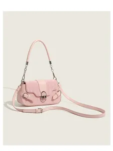 Close-up detail of the pink quilted shoulder bag featuring stylish metal lock and side buckle.