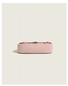 Pink leather baguette shoulder bag bottom detail showcasing clasp and smooth texture design.