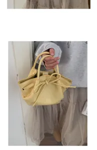 Vista dettagliata dell'elegante mini borsa a secchiello giallo chiaro con grazioso fiocco.
