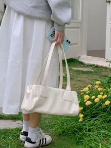 Minimalist white shoulder bag detail shot, vintage baguette style for women daily wear.