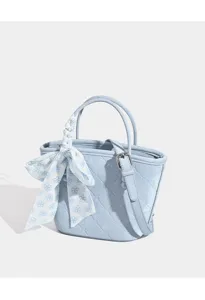 Light blue quilted bucket bag detail with floral scarf and adjustable crossbody strap.