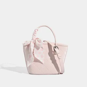 Pink bucket handbag for women, chic spring crossbody bag with sweet floral scarf and shoulder strap.