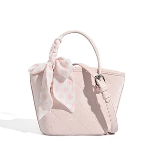 Pink quilted bucket bag for women, cute shoulder handbag with floral scarf and adjustable strap.