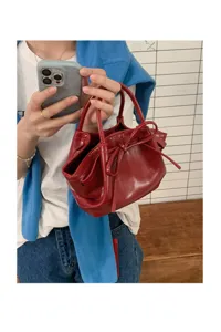 Borsa a mano con fiocco in pelle verniciata rossa da donna, elegante secchiello dettaglio.
