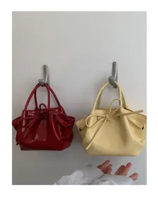 Vista dettagliata di una borsa a secchiello da donna alla moda con grazioso fiocco.