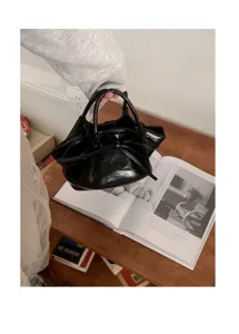 Borsa a mano nera in pelle verniciata con fiocco secchiello elegante per donna chic.