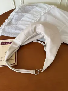 Detailaufnahme der eleganten weißen Schultertasche mit modernem gestepptem Design.