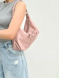 Stylish pink shoulder bag showing detailed view of vintage motorcycle underarm design.