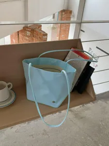 Lightweight minimalist shoulder tote bag in soft light blue, perfect daily commute accessory detail.