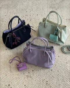 Minimalist nylon handbag with multi-compartments, stylish shoulder strap and cute mini charm.