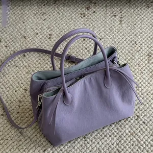 Minimalist nylon tote bag with multi-compartment design, top handles and shoulder strap.