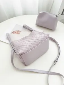 Detailed view of a chic woven leather bucket bag in soft purple with shoulder strap and pouch.