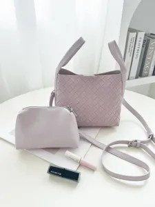 Light purple woven bucket bag detail view with matching pouch and stylish tabletop scene.