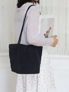 Detail shot of a minimalist black nylon shoulder tote bag, lightweight commuting casual style.