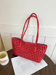 Detailed view of the red hollow woven tote bag, showing the intricate cut-out lattice design.