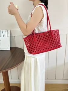 Red woven leather shoulder bag for women, stylish large capacity hollow tote bag detail.