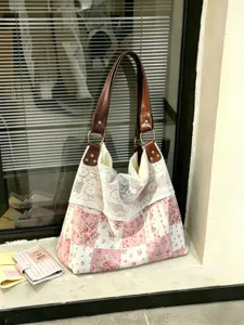 Detail view of vintage floral patchwork cloth shoulder tote bag with elegant lace trim.