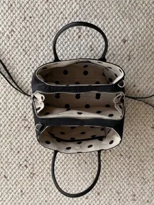 Detailed view of women's nylon multi-compartment handbag with cute polka dot inner lining.