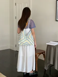 Stylish handmade crochet shoulder bag for women, casual blue yellow hollow knit beach tote.