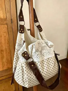 Casual polka dot canvas shoulder bag with white lace trim and brown leather straps.