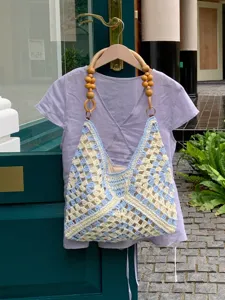Handmade crochet shoulder tote bag with wooden beaded handles for summer beach resort style.