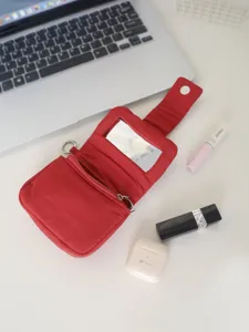 Primo piano di una pochette rossa portatile per rossetto con specchio, vista dettagliata.