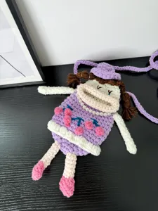 Handmade crochet cute doll phone cross-body bag detail view, unique knitted design.