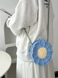 Handmade crochet flower crossbody bag detail view, soft yarn knit blue floral shoulder purse.