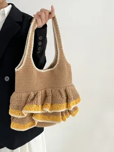 Handgemachte Häkel-Tasche Detailansicht mit Stricktextur und modischen Rüschen-Schichten.