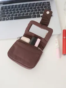 Borsa cosmetica portatile marrone con specchio integrato e dettagli tasca con zip in primo piano