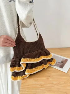 Handgemachte Häkel-Umhängetasche Detail, braune und gelbe Rüschen, gestricktes Design.