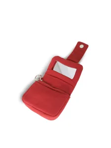 Dettaglio pochette cosmetica trapuntata rossa con specchio integrato, tasca con zip e portachiavi.