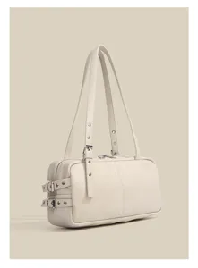 Close-up detail of retro cream white Boston shoulder bag, featuring buckle straps.