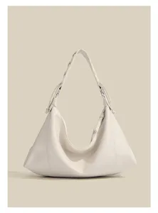 Detailed view of the elegant white hobo shoulder bag with smooth texture and braided strap.