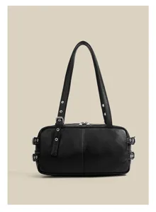 Close-up view of the black faux leather shoulder bag featuring metal eyelets, buckles and zipper.