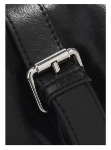 Detailed close-up of black leather bag strap and silver metal buckle craftsmanship.