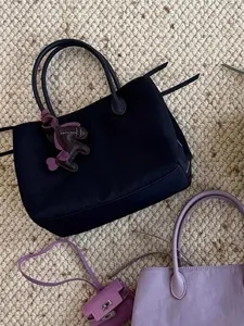 Stylish nylon tote bag with cute leather horse charm and multi-compartment design for daily use.