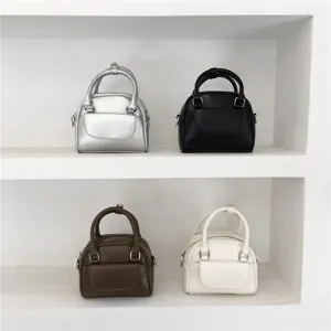 Detailed view of mini top-handle shoulder bags in silver, black, brown, and white colors.