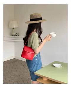 Minimalist red leather shoulder bag detailed shot, stylish daily crossbody bucket bag.
