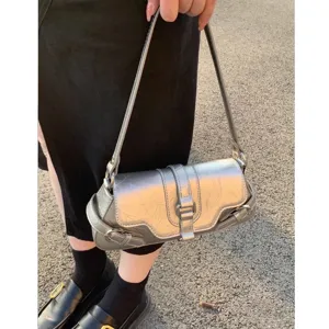 Silver metallic underarm bag with trendy motorcycle style design and chic decorative straps.