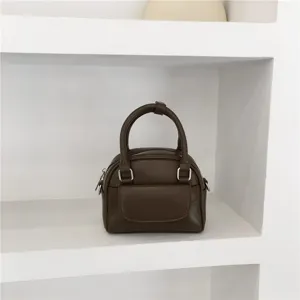 Dark brown small handbag with top handle and front pocket for women, versatile crossbody.