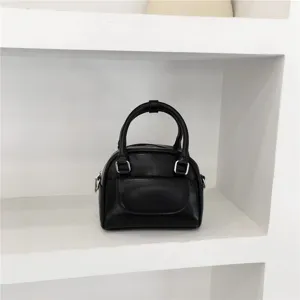 Minimalist black mini shoulder bag with top handle and front flap pocket for women style.