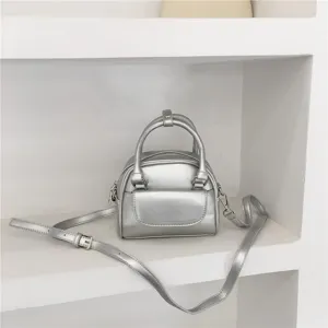 Silver mini handbag detail showing metallic finish, dual handles, and front pocket design.