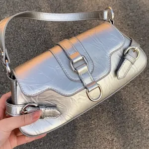 Silver metallic shoulder bag detail showing stylish buckle and premium leather texture.