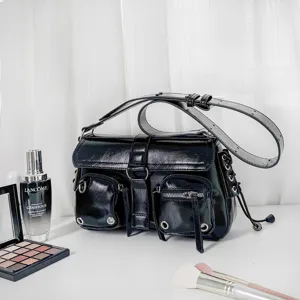Black glossy motorcycle shoulder bag for women, edgy multi-pocket design, versatile fashion handbag.