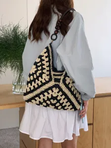 Detailed view of a stylish summer crochet straw shoulder tote bag with wooden bead strap in use.